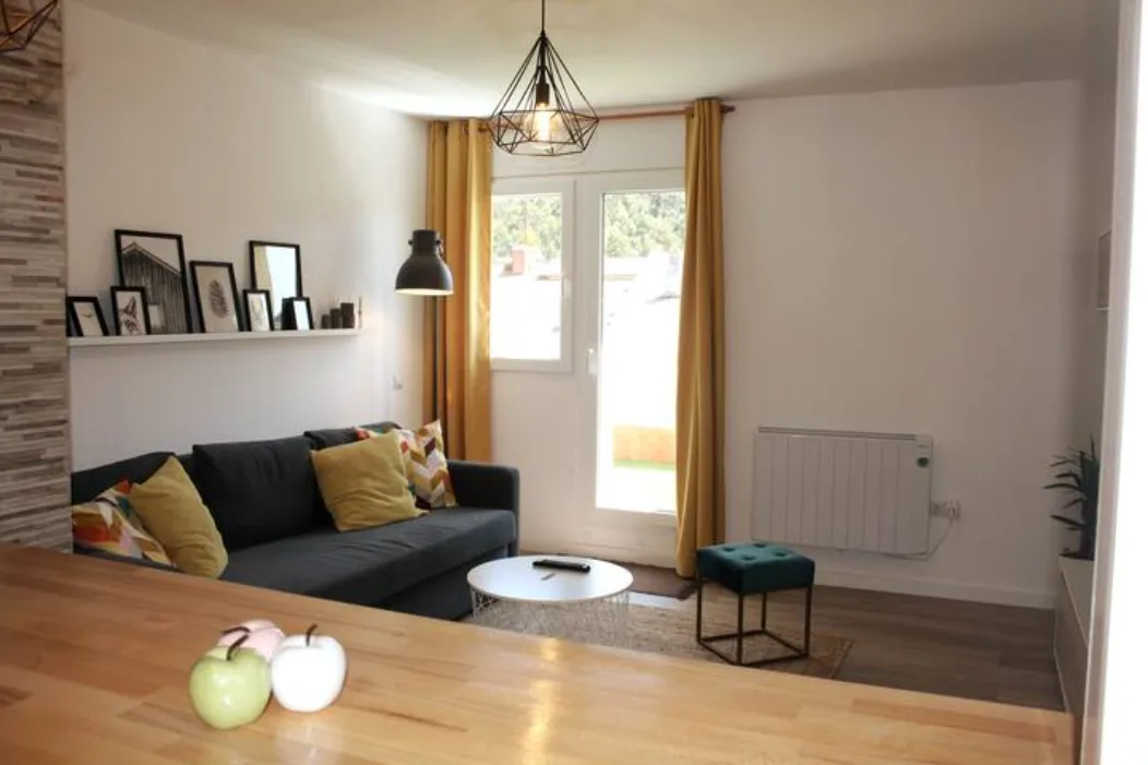 Salón luminoso con sofá cómodo, decoración moderna y acceso a terraza en alojamiento turístico en Galicia